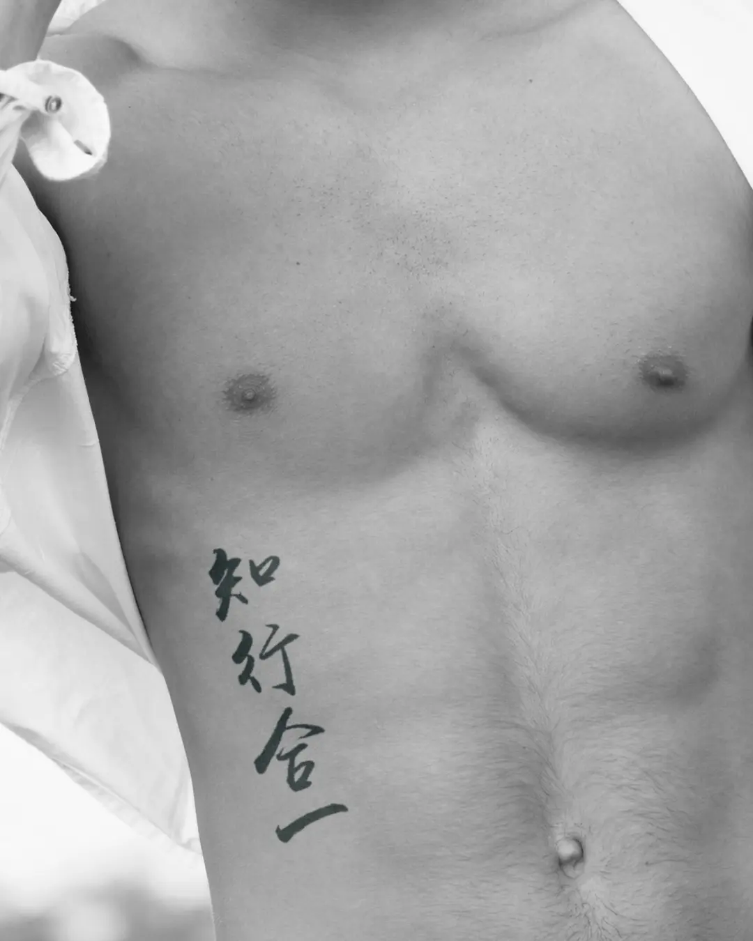 The male model has a Zhi Xing He Yi tattoo inked across his waist.